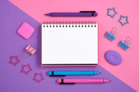 Empty note with pink, blue and violet pen, erasers on magenta and purple back Stock Photos