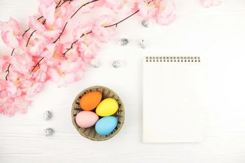 Empty notebook and basket with eggs on Easter background. Stock Photos