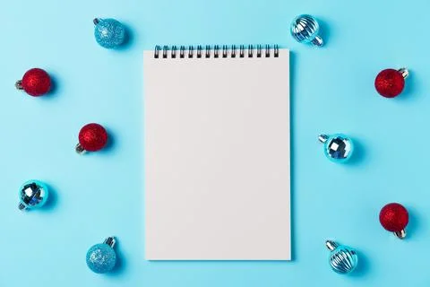Empty notebook with balls on blue background from above. Christmas concept... Stock Photos