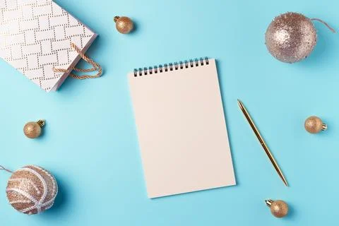 Empty notebook with Christmas decorations on blue background from above. Fl.. Stock Photos