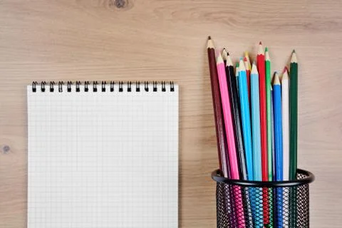 Empty notebook with colorful pencils on table Stock Photos