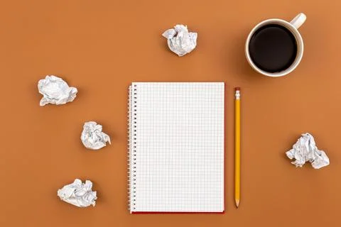 Empty notebook with cup of coffee and crumpled paper balls, flat lay. Stock Photos