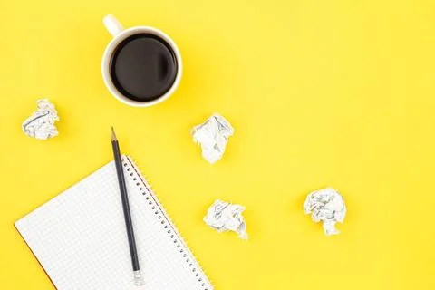 Empty notebook with cup of coffee and crumpled paper balls, flat lay. Stock Photos