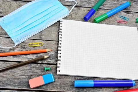 Empty notebook with face mask and many school tools Stock Photos