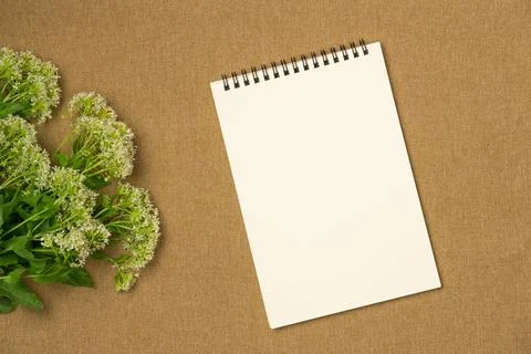 Empty notebook with flowers on fabric background. Flat lay, top view. Space f Stock Photos
