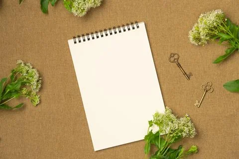 Empty notebook with flowers on fabric background. Flat lay, top view. Space f Stock Photos