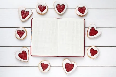 Empty notebook frame for design text and heart shaped cookies on white wooden Stock Photos