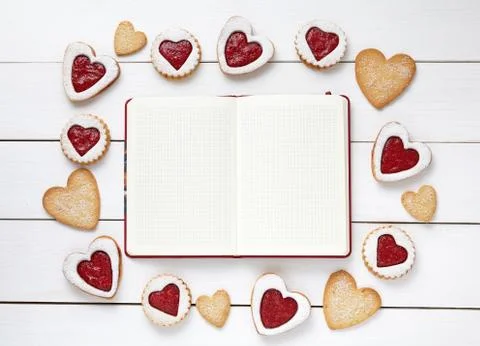 Empty notebook frame for design text and heart shaped cookies on white wooden Stock Photos
