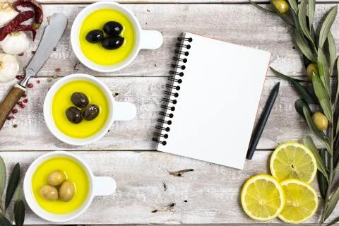 Empty notebook with olives on wooden background Stock Photos