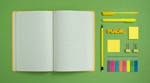 Empty notebook page for your text with yellow stationery on green backdrop Foto stock
