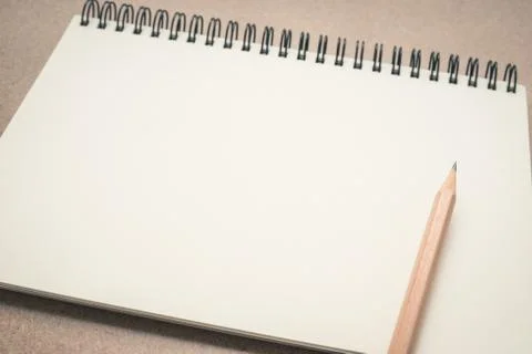 Empty notebook paper with brown pencil on the table Stock Photos