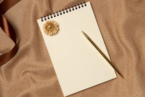 Empty notebook with pen on a fabric background from above. Copy space Stock Photos