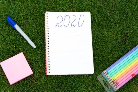 Empty notebook ready for New 2020 Year planing or wish list in the grass with Stock Photos