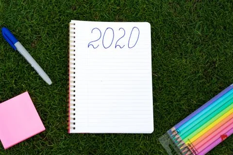 Empty notebook ready for New 2020 Year planing or wish list in the grass with Stock Photos