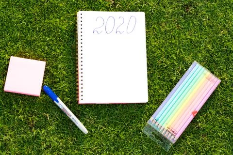 Empty notebook ready for New 2020 Year planing or wish list in the grass with Stock Photos