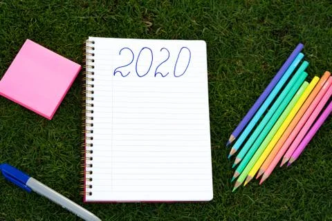 Empty notebook ready for New 2020 Year planing or wish list in the grass with Stock Photos