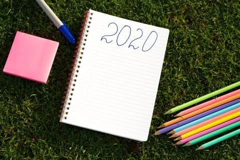 Empty notebook ready for New 2020 Year planing or wish list in the grass with Stock Photos