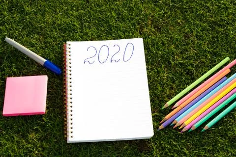 Empty notebook ready for New 2020 Year planing or wish list in the grass with Stock Photos