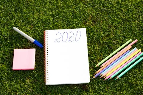 Empty notebook ready for New 2020 Year planing or wish list in the grass with Stock Photos