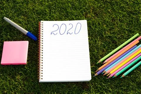 Empty notebook ready for New 2020 Year planing or wish list in the grass with Stock Photos