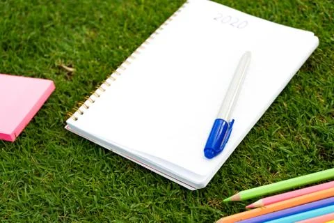 Empty notebook ready for New 2020 Year planing or wish list in the grass with Stock Photos