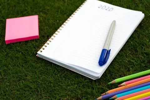 Empty notebook ready for New 2020 Year planing or wish list in the grass with Stock Photos