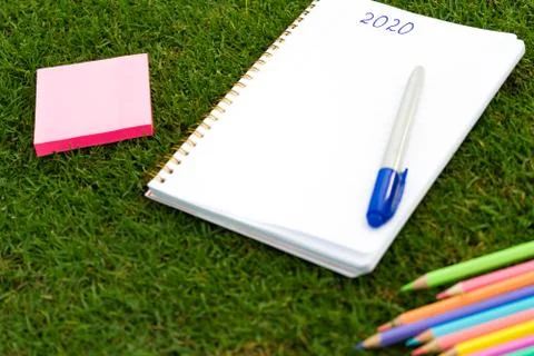 Empty notebook ready for New 2020 Year planing or wish list in the grass with Stock Photos