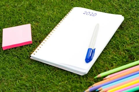 Empty notebook ready for New 2020 Year planing or wish list in the grass with Stock Photos