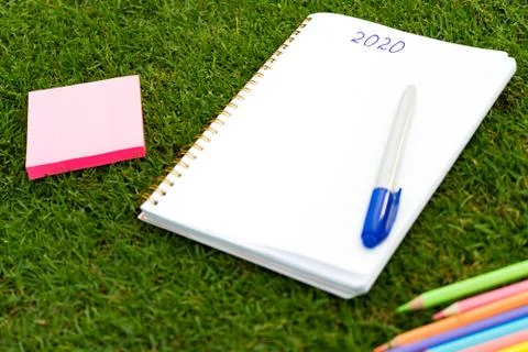 Empty notebook ready for New 2020 Year planing or wish list in the grass with Stock Photos