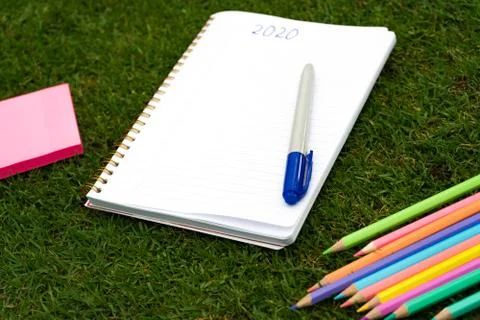 Empty notebook ready for New 2020 Year planing or wish list in the grass with Stock Photos