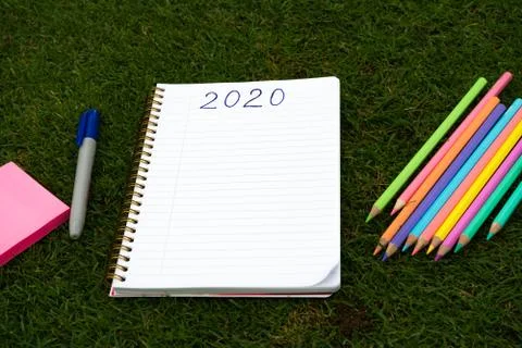 Empty notebook ready for New 2020 Year planing or wish list in the grass with Stock Photos
