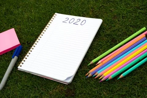 Empty notebook ready for New 2020 Year planing or wish list in the grass with Stock Photos