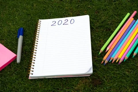 Empty notebook ready for New 2020 Year planing or wish list in the grass with Stock Photos
