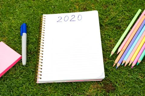 Empty notebook ready for New 2020 Year planing or wish list in the grass with Stock Photos