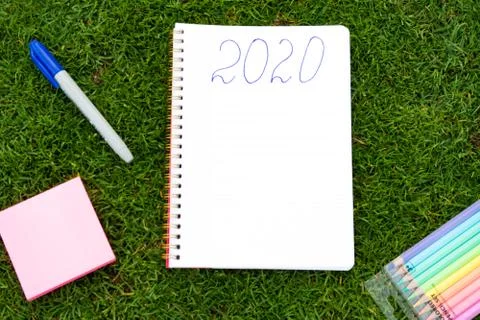 Empty notebook ready for New 2020 Year planing or wish list in the grass with Stock Photos