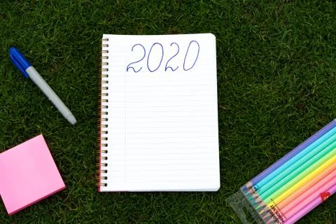 Empty notebook ready for New 2020 Year planing or wish list in the grass with Stock Photos