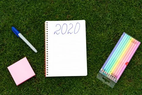 Empty notebook ready for New 2020 Year planing or wish list in the grass with Stock Photos