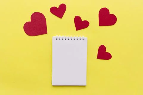 Empty notebook with red heart on yellow background with space for your text Stock Photos