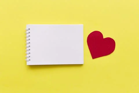 Empty notebook with red heart on yellow background with space for your text Stock Photos