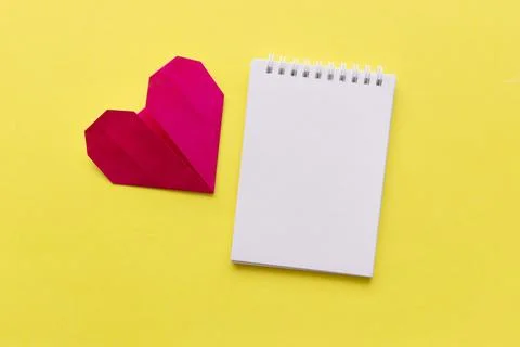 Empty notebook with red heart on yellow background with space for your text Stock Photos
