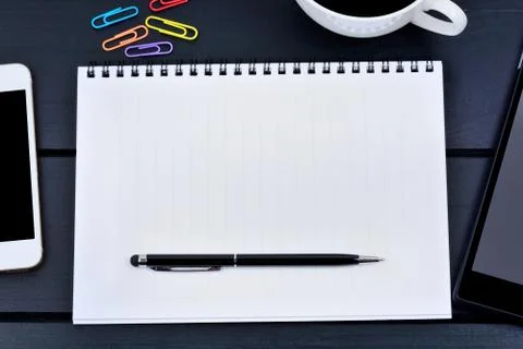 Empty notebook with telephone and digital tablet on a wooden table Stock Photos