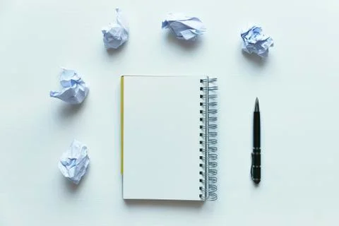 Empty notebook on wooden table with crumpled papers around Stock Photos