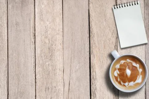Empty notepad and hot coffee on desk, top view, copy space, business working  Stock Photos