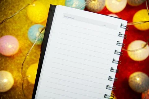 Empty notepad mockup and LED cotton balls decoration on red and yellow bokeh  Stock Photos