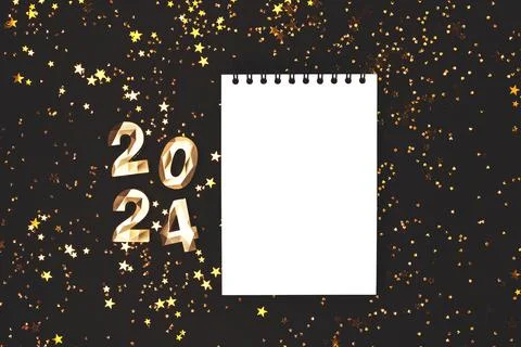 Empty notepad mockup, glowing stars confetti and 2024 golden numbers. Stock Photos