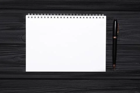 Empty notepad with place for text and pen on a black wooden background Stock Photos