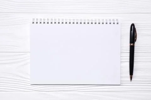 Empty notepad with place for text and pen on a white wooden background Stock Photos