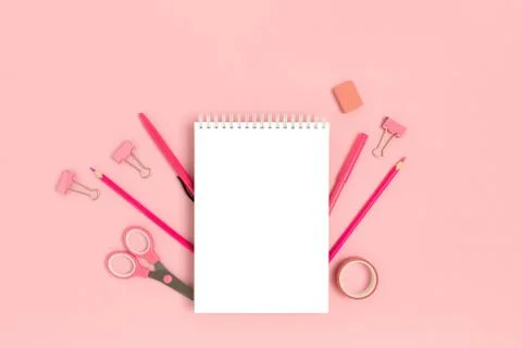 Empty notepad template with office supplies on a pink pastel background. Stock Photos