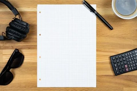 An empty notepad together with a pen, a calculator, a cup of coffee and headp Stock Photos