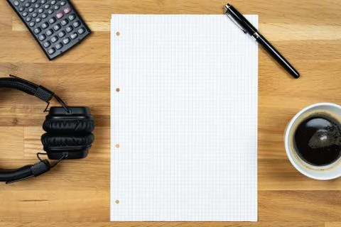 An empty notepad together with a pen, a calculator, a cup of coffee and headp Stock Photos